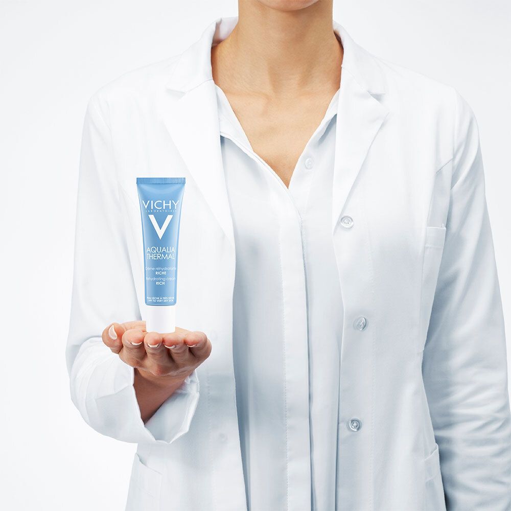 Personne en blouse blanche tenant un tube bleu Vichy Aqualia Thermal. Texte.