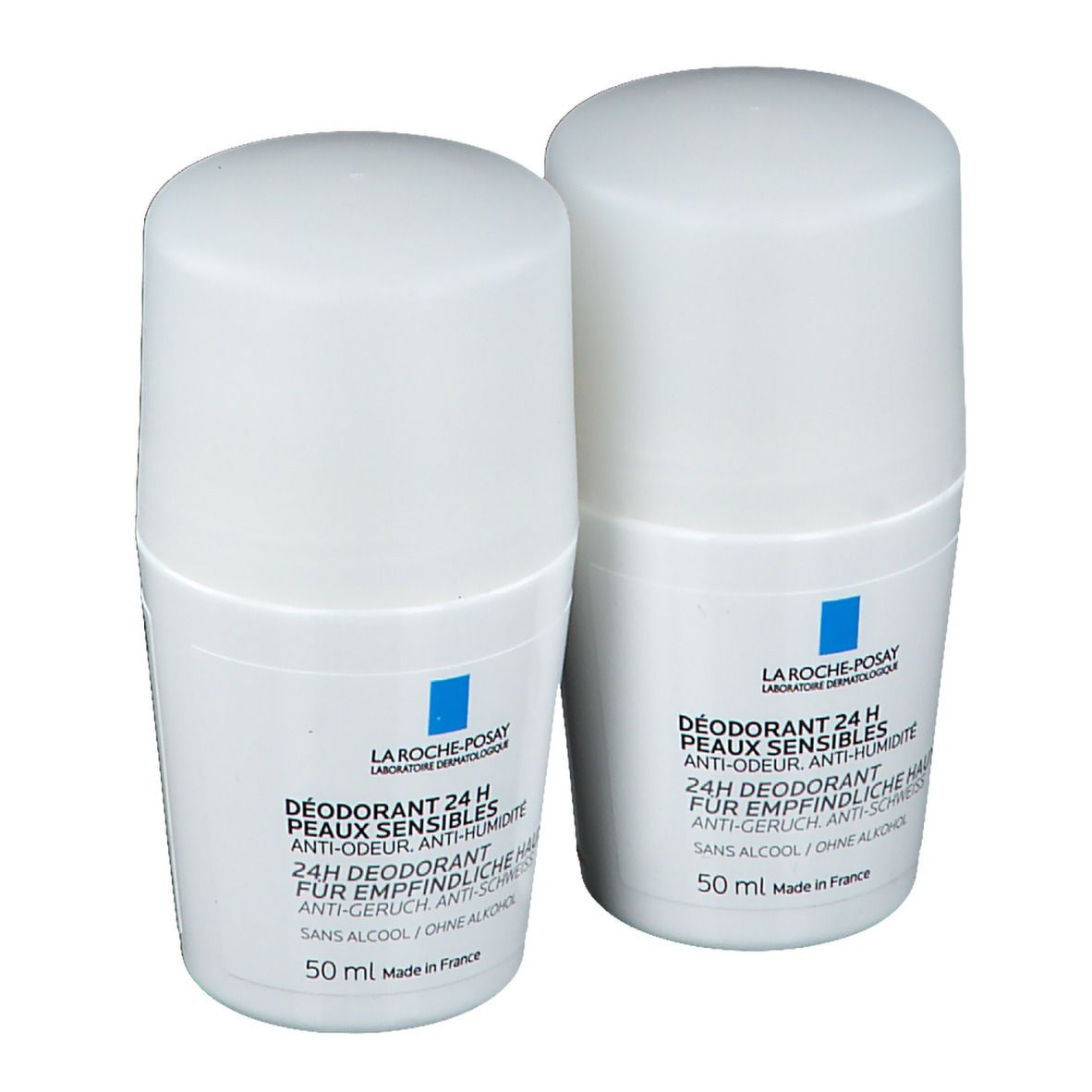 Deux déodorants roll-on blancs. Carrés bleus avec logo. Texte: DÉODORANT 24 H PEAUX SENSIBLES, 50 ml. Anti-odeur, anti-humidité.