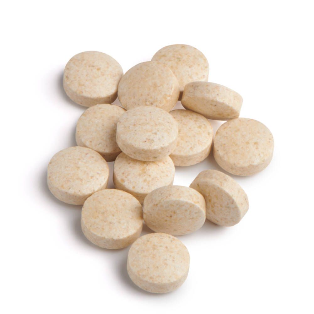 Stapel lichtbruine, ronde tabletten. Meerdere tabletten liggen op elkaar. Geen verpakking zichtbaar.