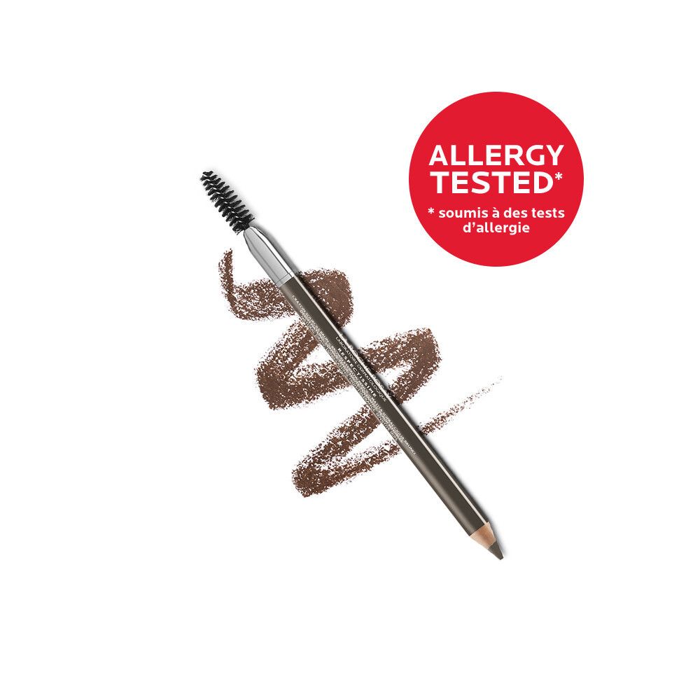 Crayon à sourcils avec brosse et capuchon. Mine marron foncé, corps argenté, brosse noire. Marque visible.