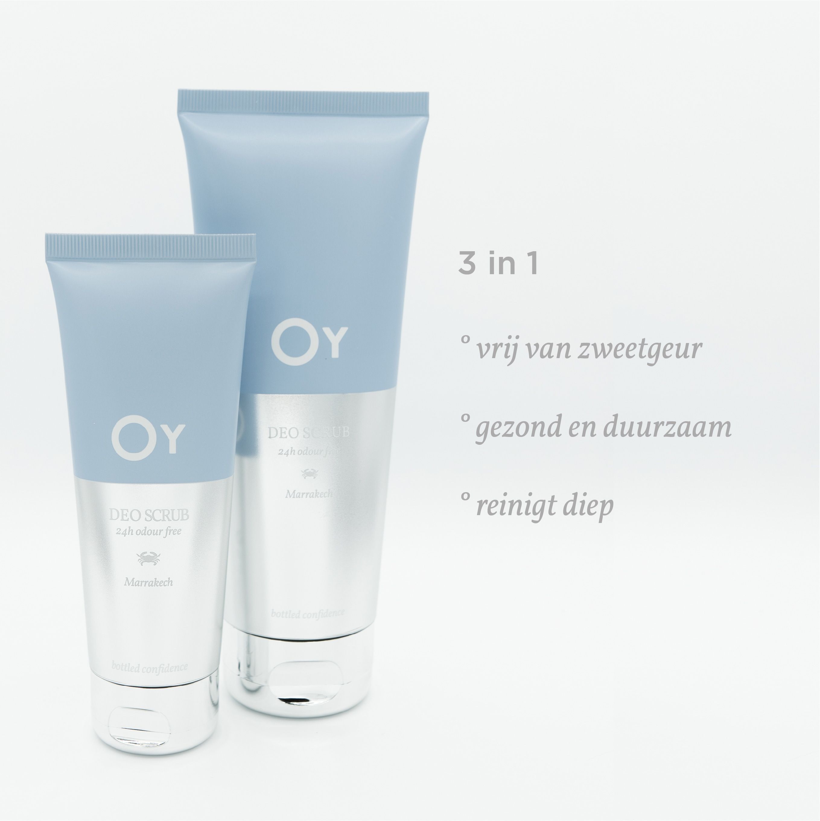 Twee tubes. OY-logo en 'DEO SCRUB'. Tekst in meerdere talen. Lichtblauwe achtergrond.