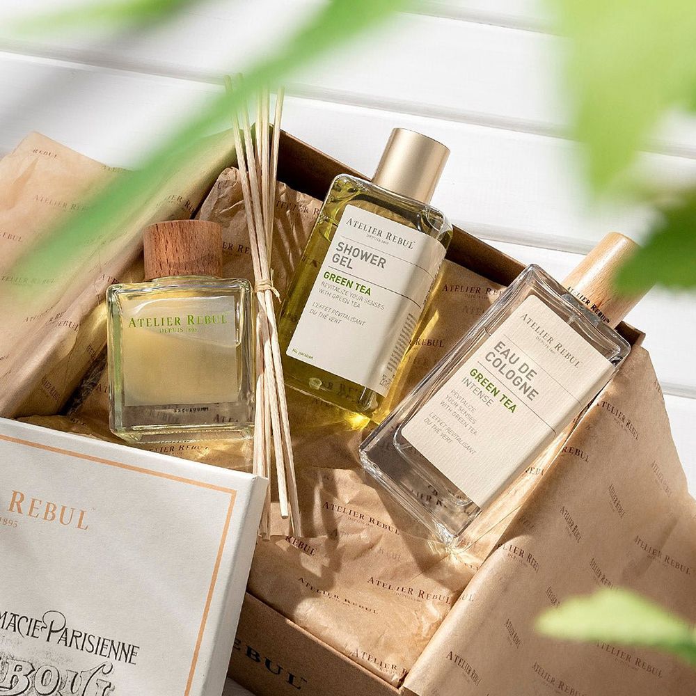 Geschenkset mit ATELIER REBUL Produkten. Enthält Diffusor, Duschgel und Eau de Cologne. Auf braunem Papier.