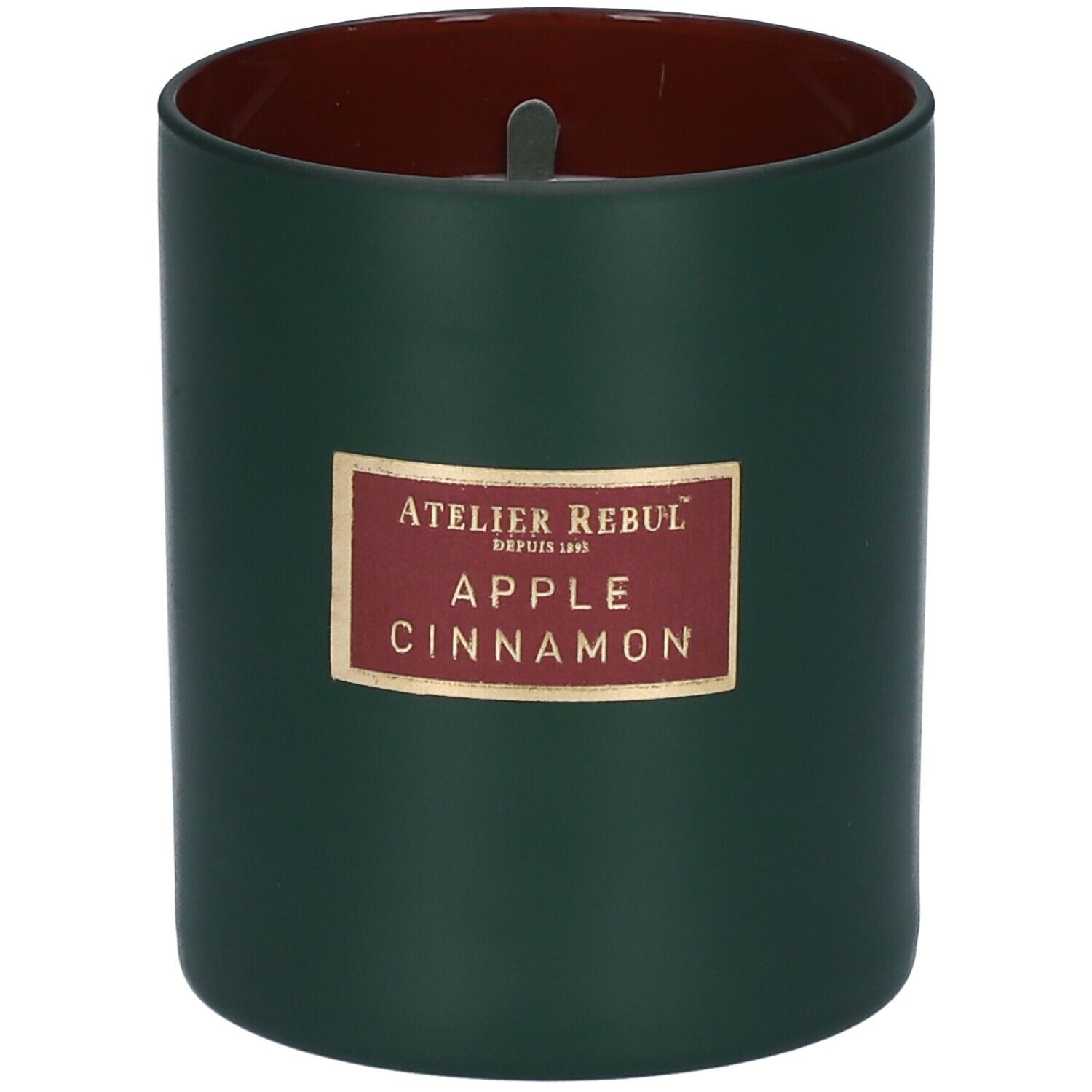 Groene kaars met rode binnenkant. Label met "ATELIER REBUL", "APPLE CINNAMON".