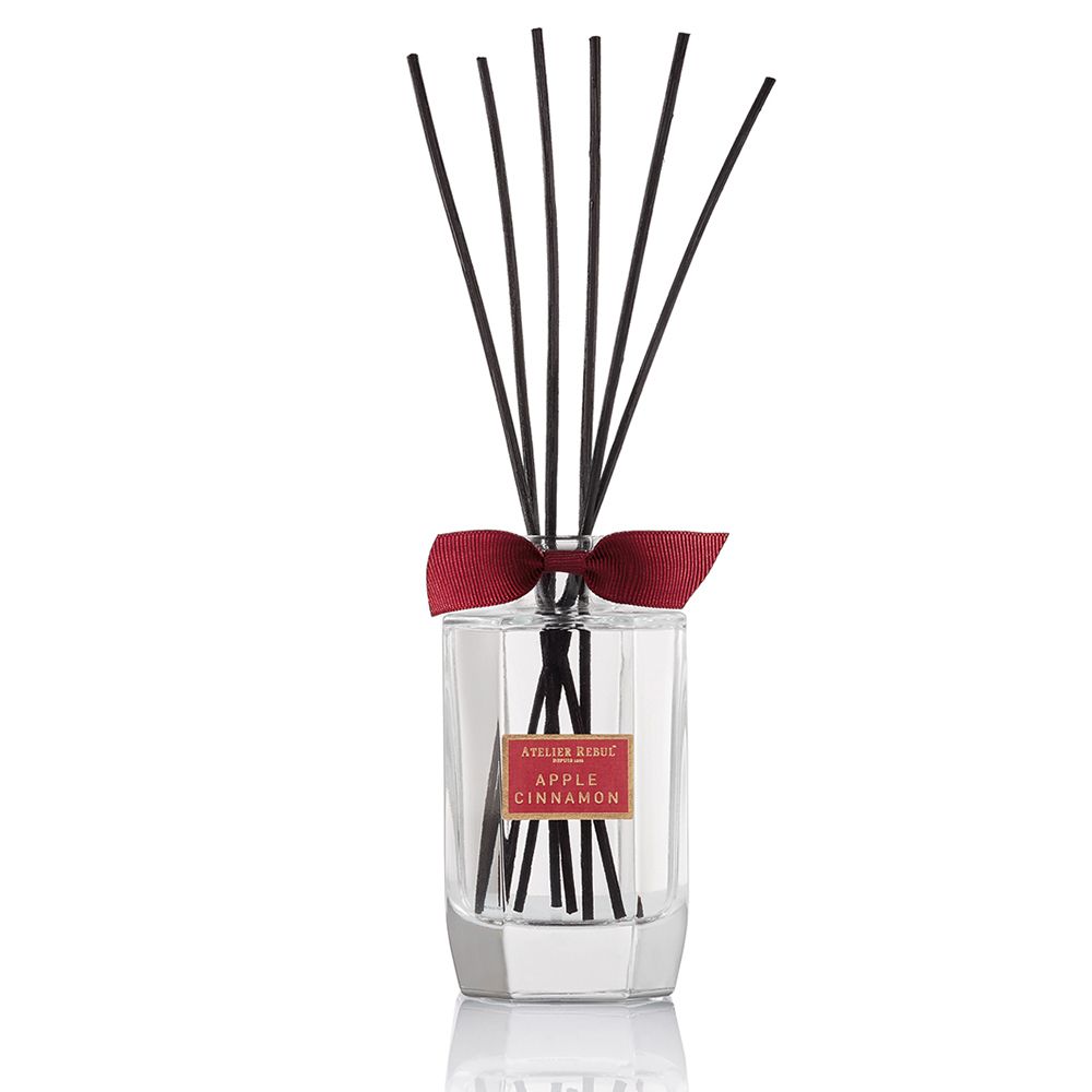 Glazen fles met zwarte stokjes en rode strik. Productlabel met productnaam.