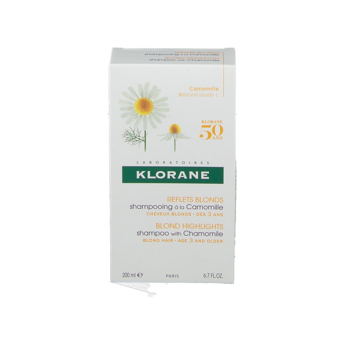 Boîte de shampooing KLORANE. Inscription: Blond Highlights, 50 ans. Illustration de camomille.