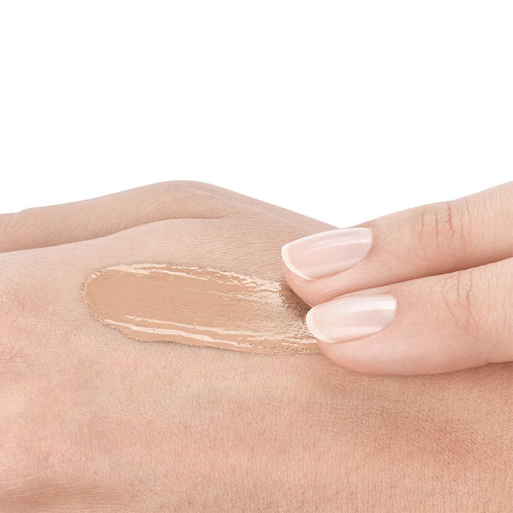Maquillage appliqué sur la main. Couleur beige clair. Texture visible.
