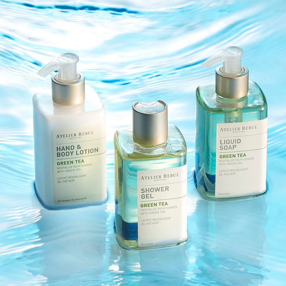Drie flessen op blauwe achtergrond. Hand- en bodylotion, douchegel en vloeibare zeep. Alle met pomp.