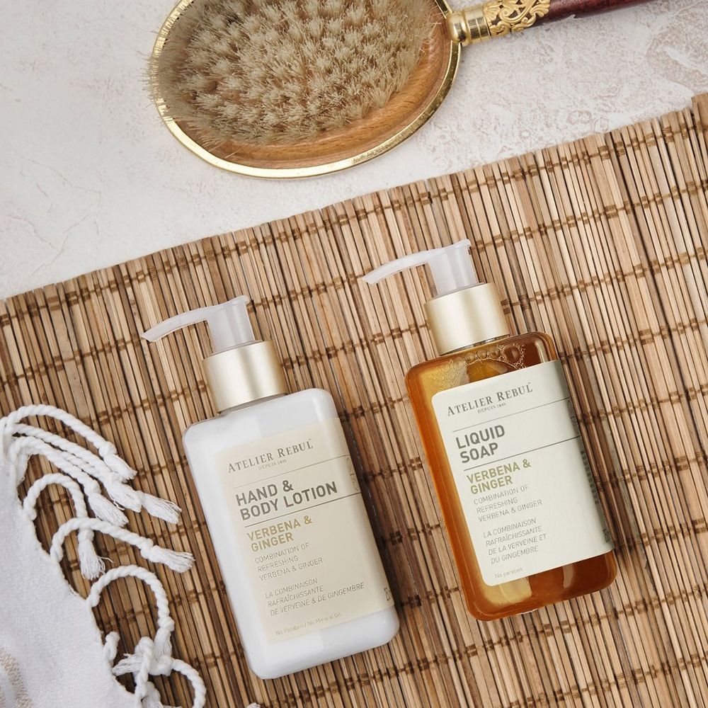 Zwei Flaschen auf Bambusmatte. Eine Hand & Body Lotion, eine Liquid Soap. Beide mit Pumpverschluss.