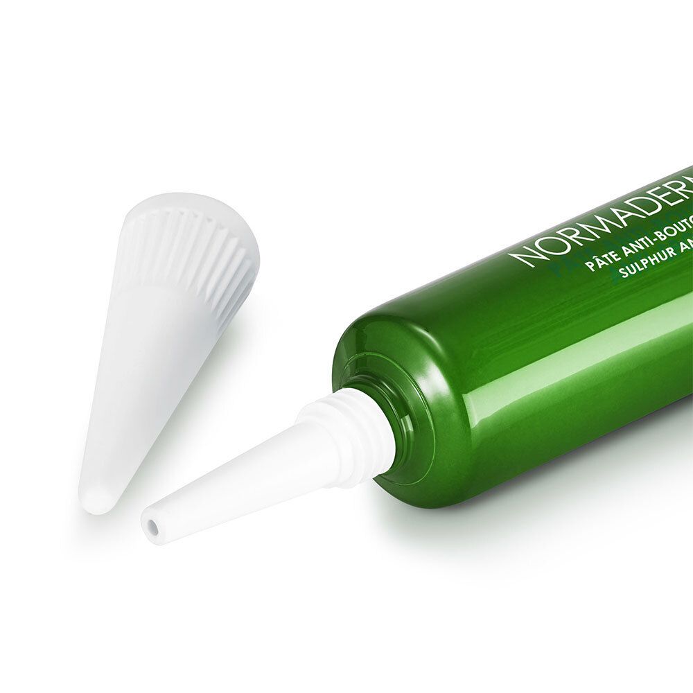 Tube vert avec embout blanc. Bouchon à côté. Nom du produit : Normaderm S.O.S. Pâte Anti-Boutons au Soufre.