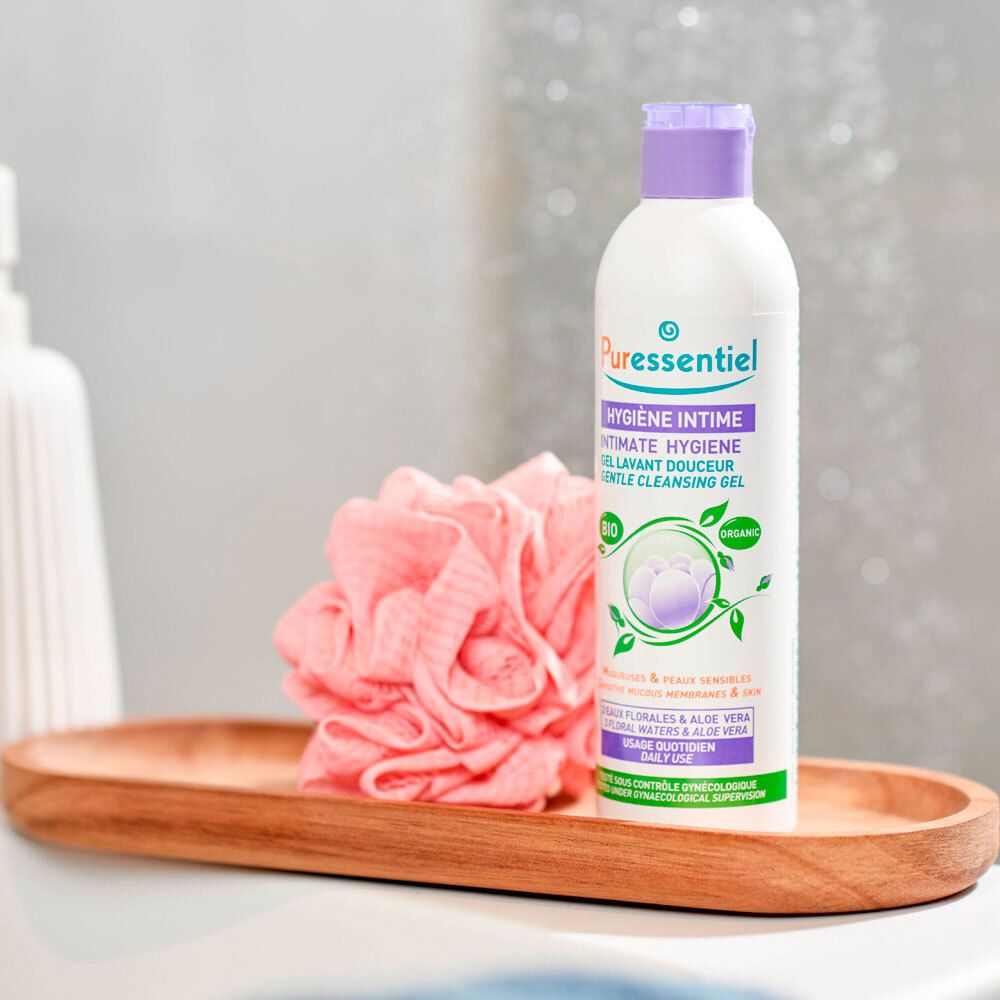 Flacon, bouchon violet, sur plateau en bois. Inscription: Puressentiel Hygiène Intime Gel Lavant Douceur. Certifié Bio.