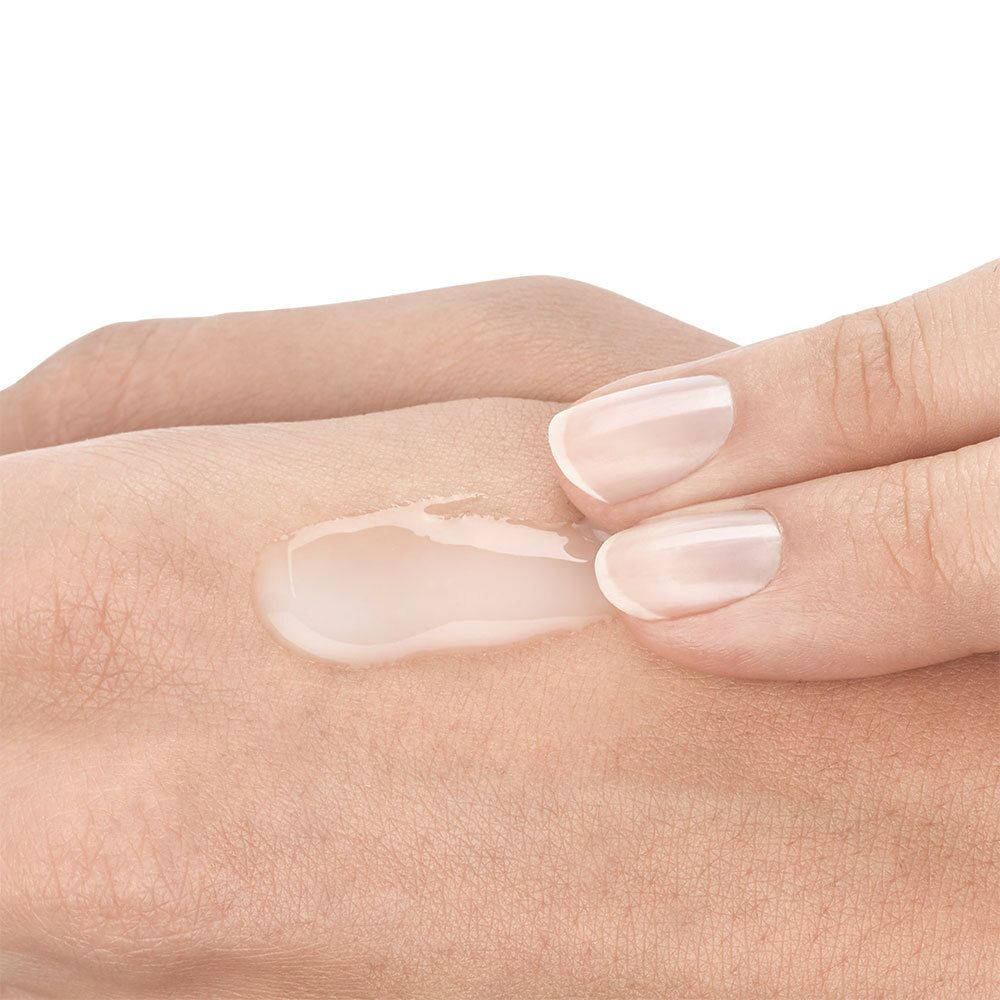 Close-up van een hand met aangebrachte, transparante vloeistof. Product onbekend.