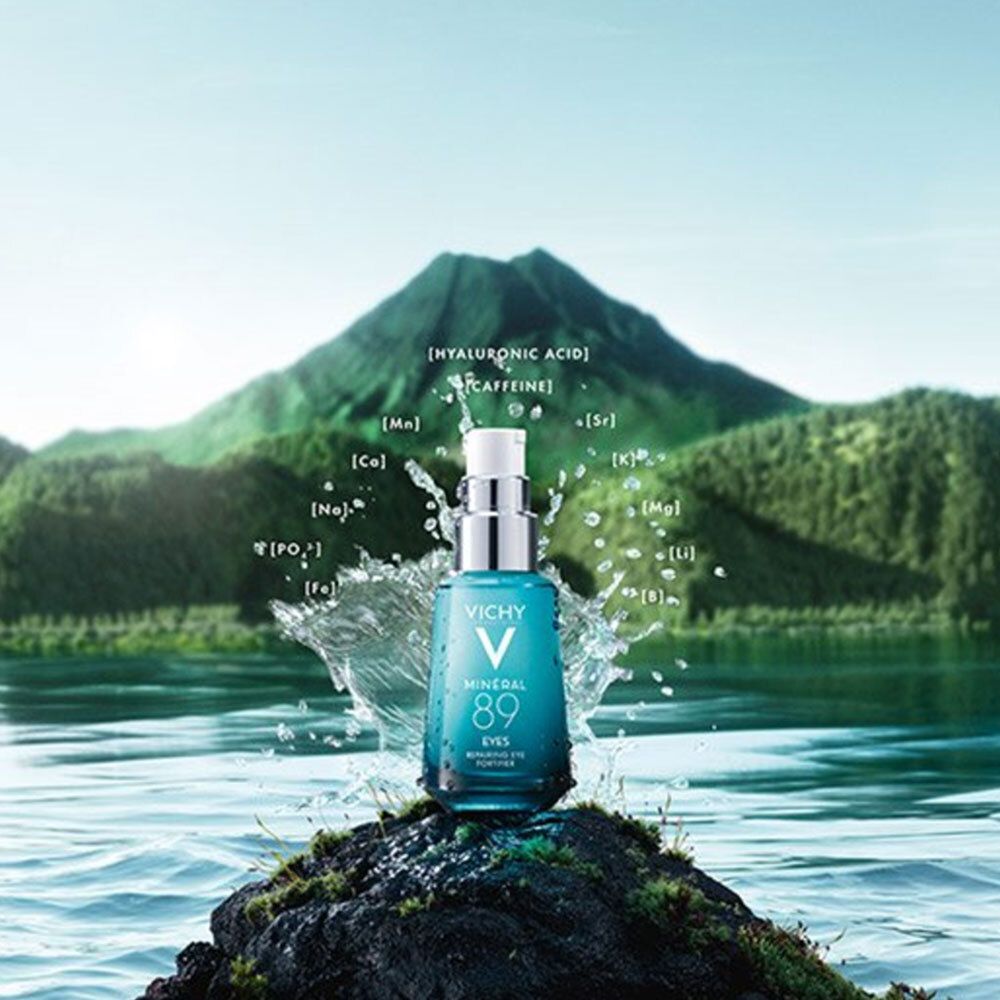 Vichy Mineral 89 Eyes voor landschap. Fles op rots, spatten. Bergen op de achtergrond.