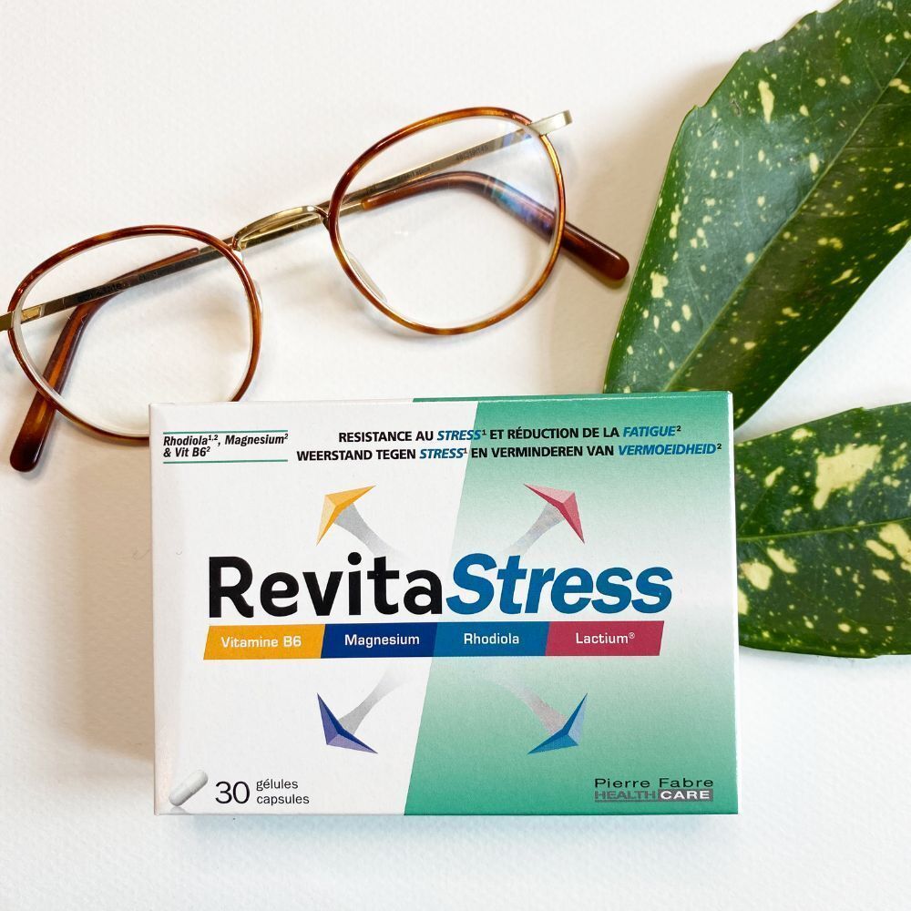 Boîte "RevitaStress" avec lunettes et feuille. Inscriptions: Vitamine B6, Magnésium, Rhodiola, Lactium. 30 gélules.