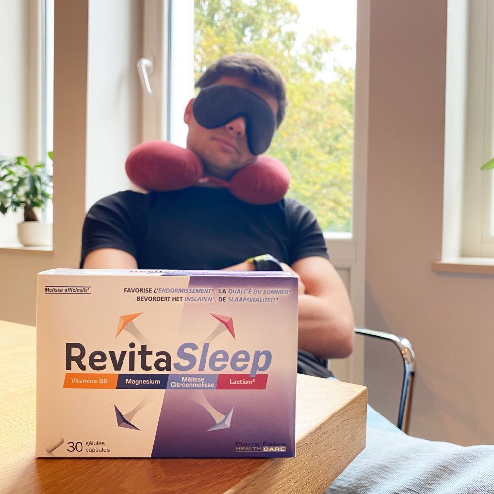 Homme avec masque de sommeil et coussin de nuque, à côté d'une boîte RevitaSleep. Inscriptions : Vitamine B6, Magnésium, Mélisse, Lactium.