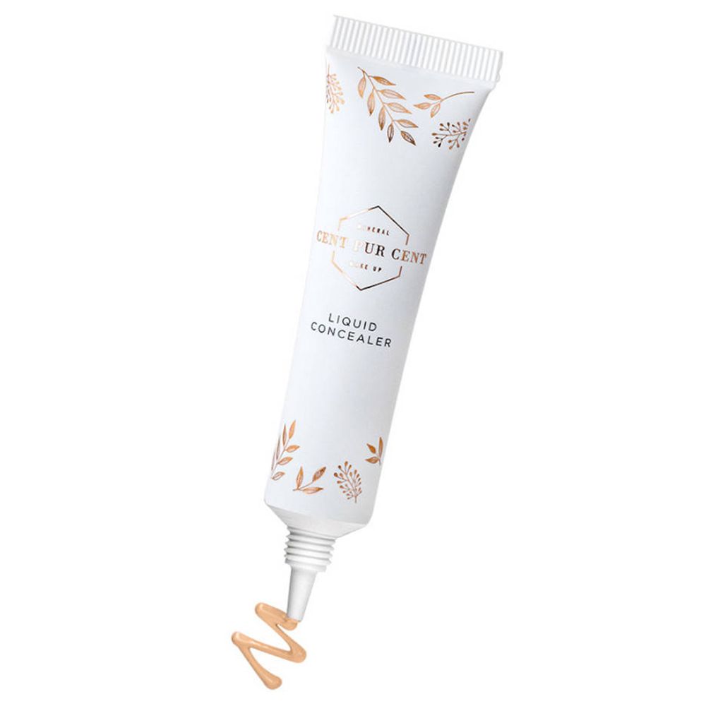 Witte tube met gouden bladeren en tekst. Vloeibare concealer komt uit de opening.