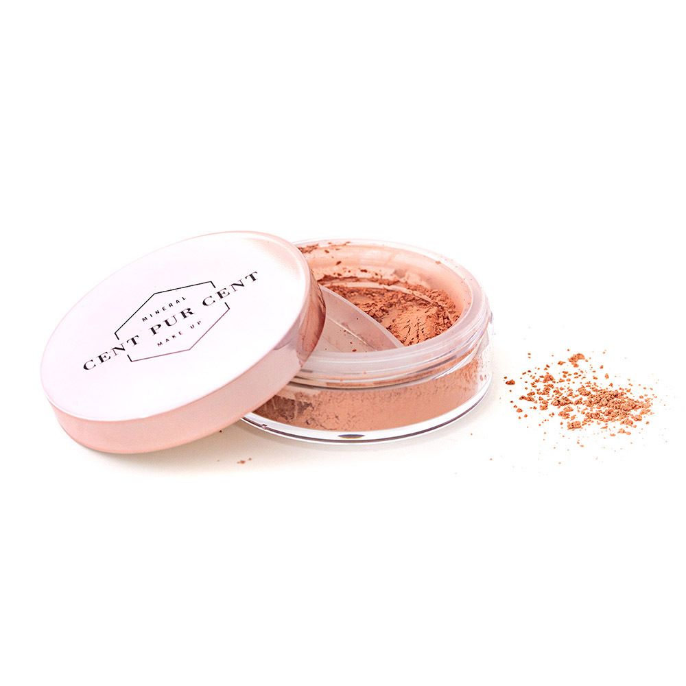 Récipient ouvert avec contenu rose. Le couvercle porte le nom de la marque. Un applicateur est visible.