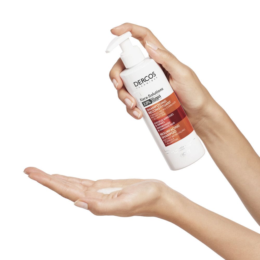 Persoon houdt een shampoo fles vast. Product voor beschadigd haar.