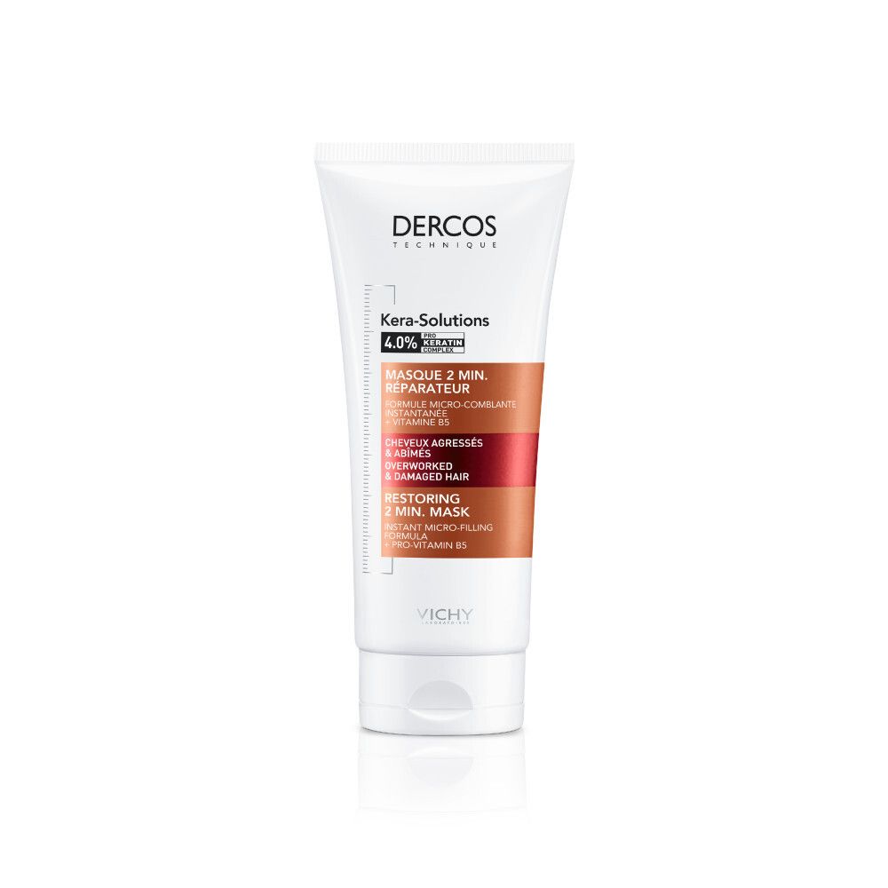 Mains tenant un tube et du produit. Inscriptions: Dercos, Kera-Solutions, Masque 2 min. réparateur. Produit dans la paume.