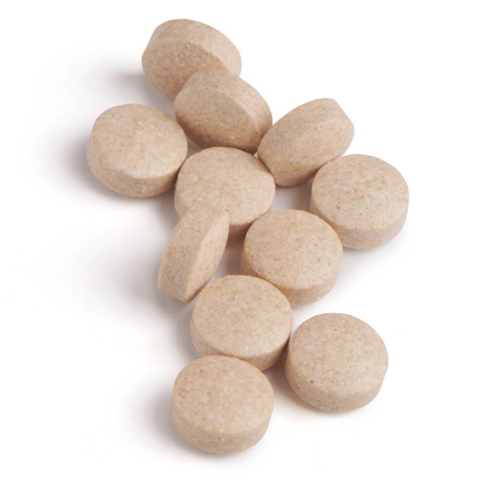 Tien ronde, beige tabletten. Geen verpakking zichtbaar.
