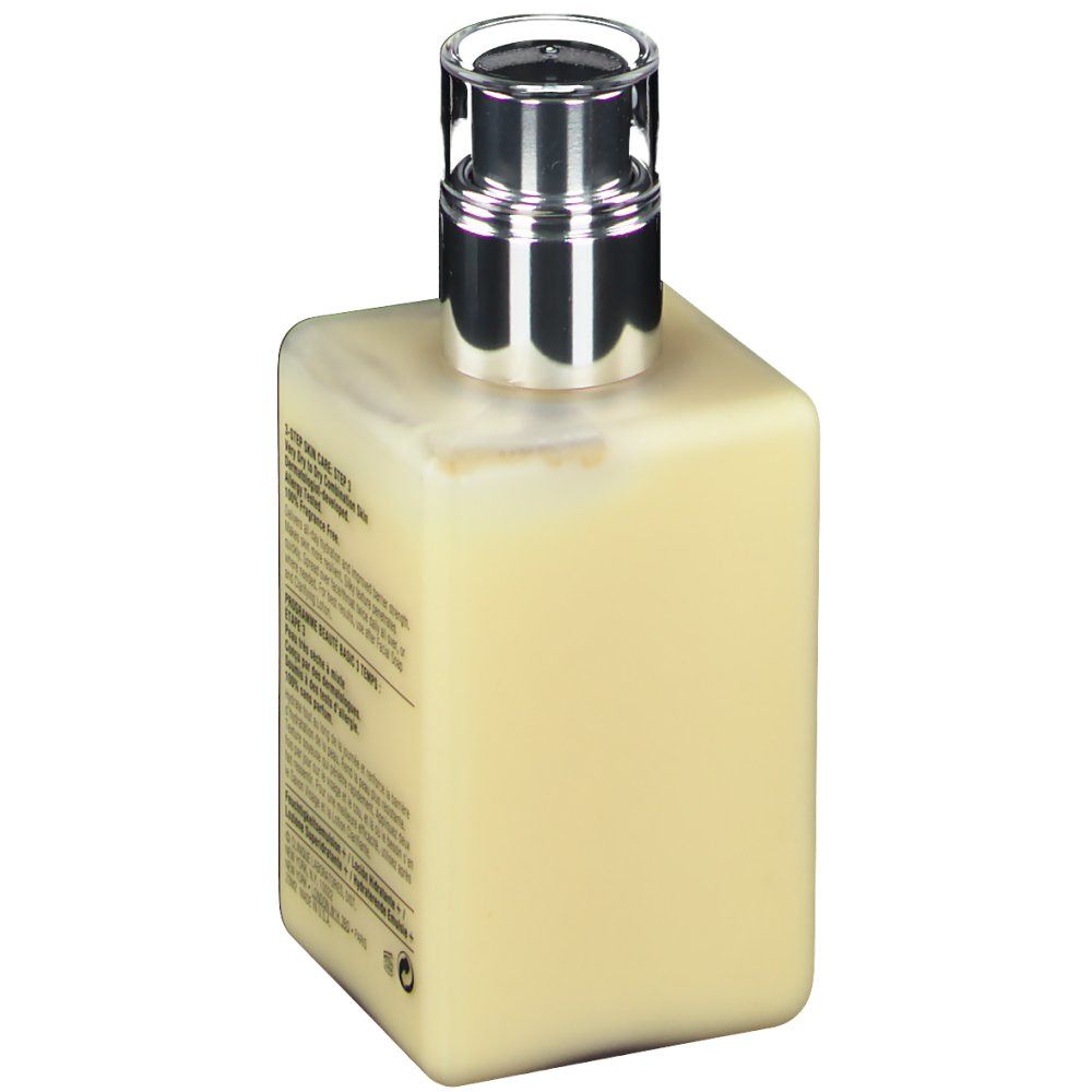 Vue arrière du flacon de lotion. Texte multilingue. Pompe argentée. Liquide beige visible.