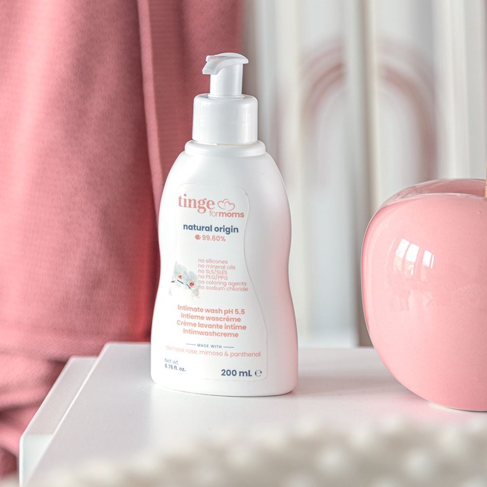 Witte fles met pomp op wit oppervlak. Opschrift: tinge for moms, Intieme wascrème pH 5,5. 200 ml.
