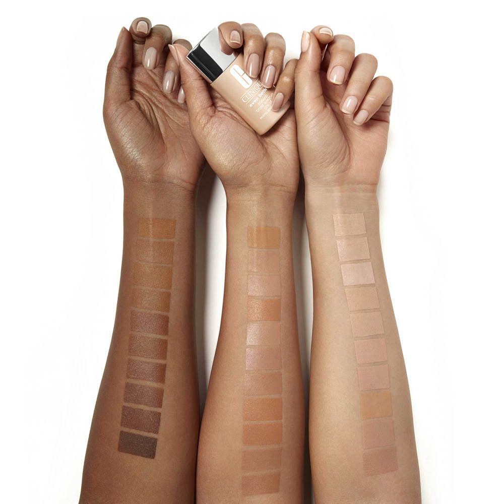 Drei Unterarme mit aufgetragenen Foundation-Swatches in verschiedenen Hauttönen. Eine Flasche Foundation ist sichtbar.