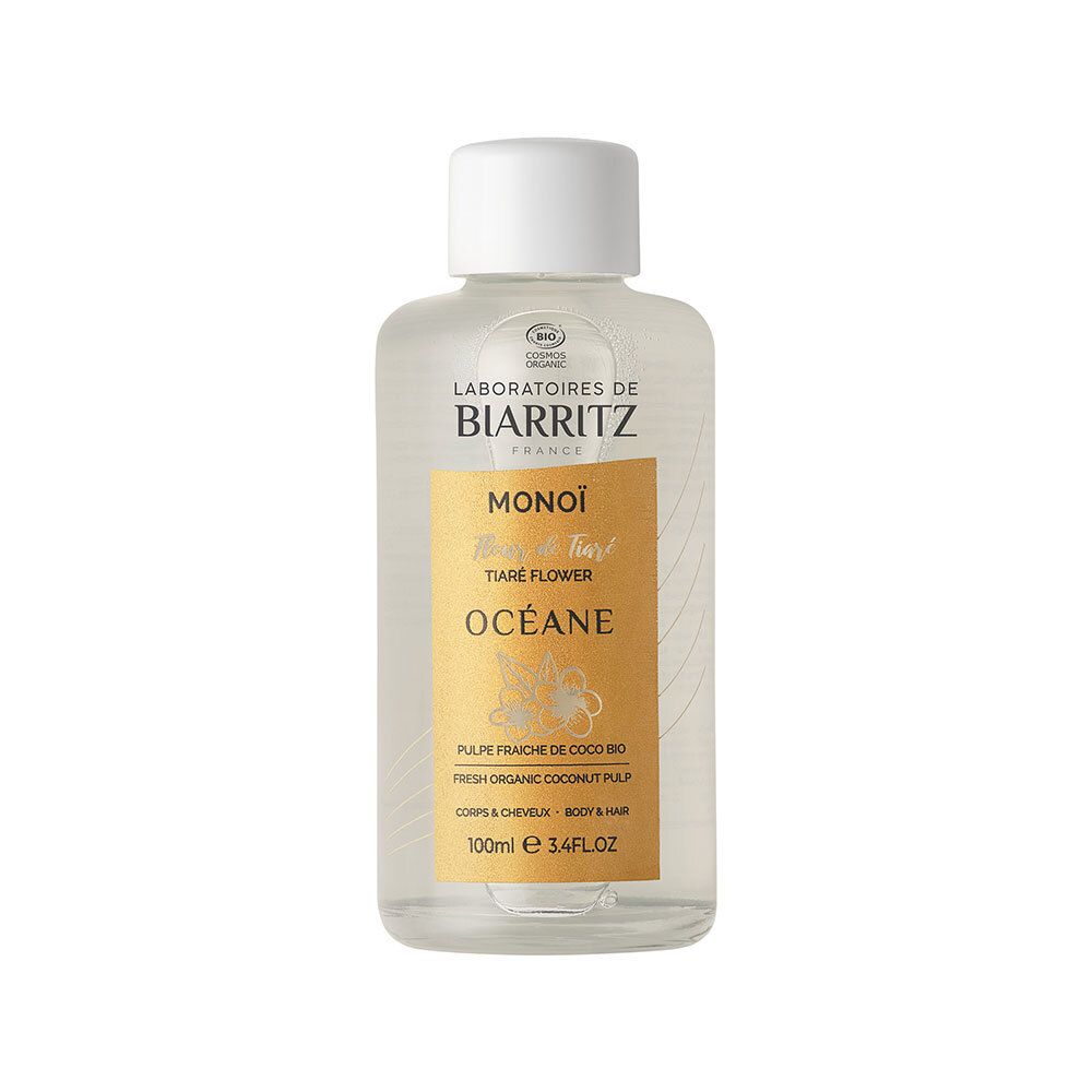 Flacon transparent avec bouchon blanc. Inscriptions: LABORATOIRES DE BIARRITZ, MONOÏ, OCÉANE. Étiquette dorée.