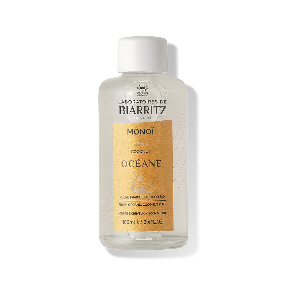 Flacon transparent avec bouchon blanc. Inscription: Laboratoires de Biarritz, Monoi Océane, noix de coco. Étiquette jaune.
