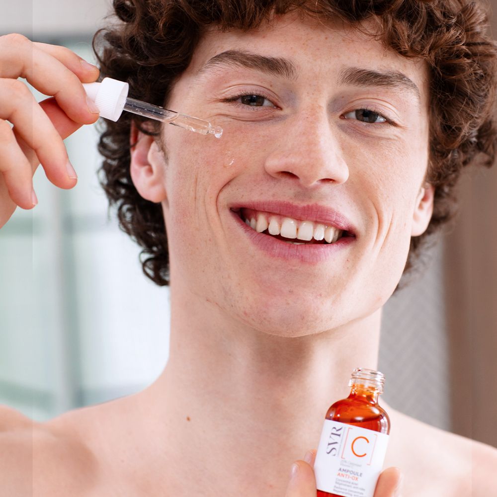 Homme tenant flacon et pipette. Nom du produit : Ampoule Anti-Ox.