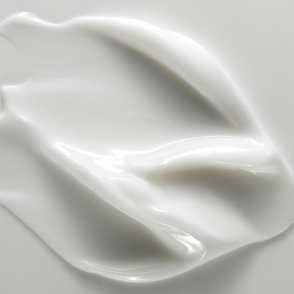Gros plan de crème blanche. Texture lisse, disposée en vagues.