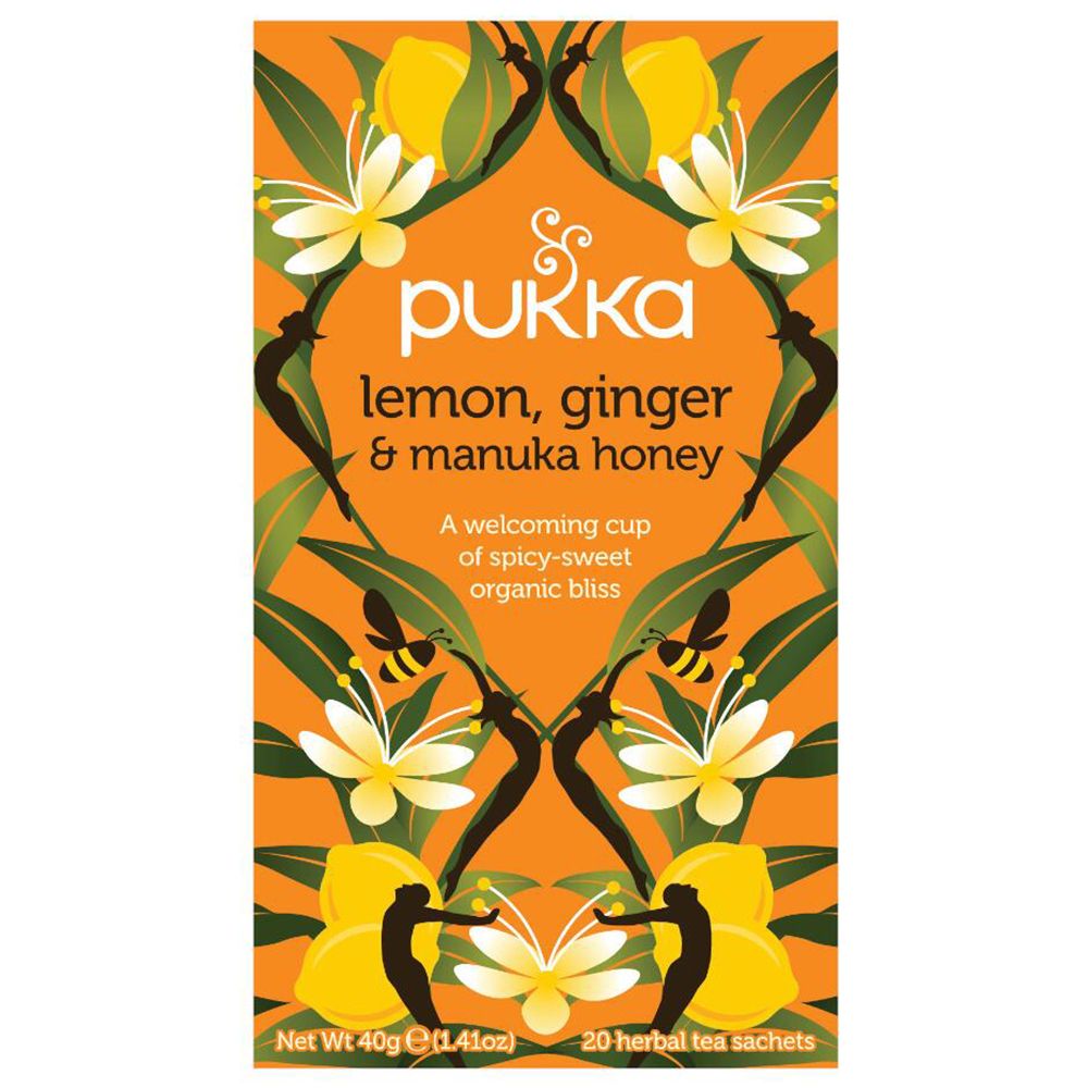 Boîte de thé Pukka. Inscription : Lemon, Ginger & Manuka Honey. 20 sachets. Design jaune-orangé avec éléments floraux.