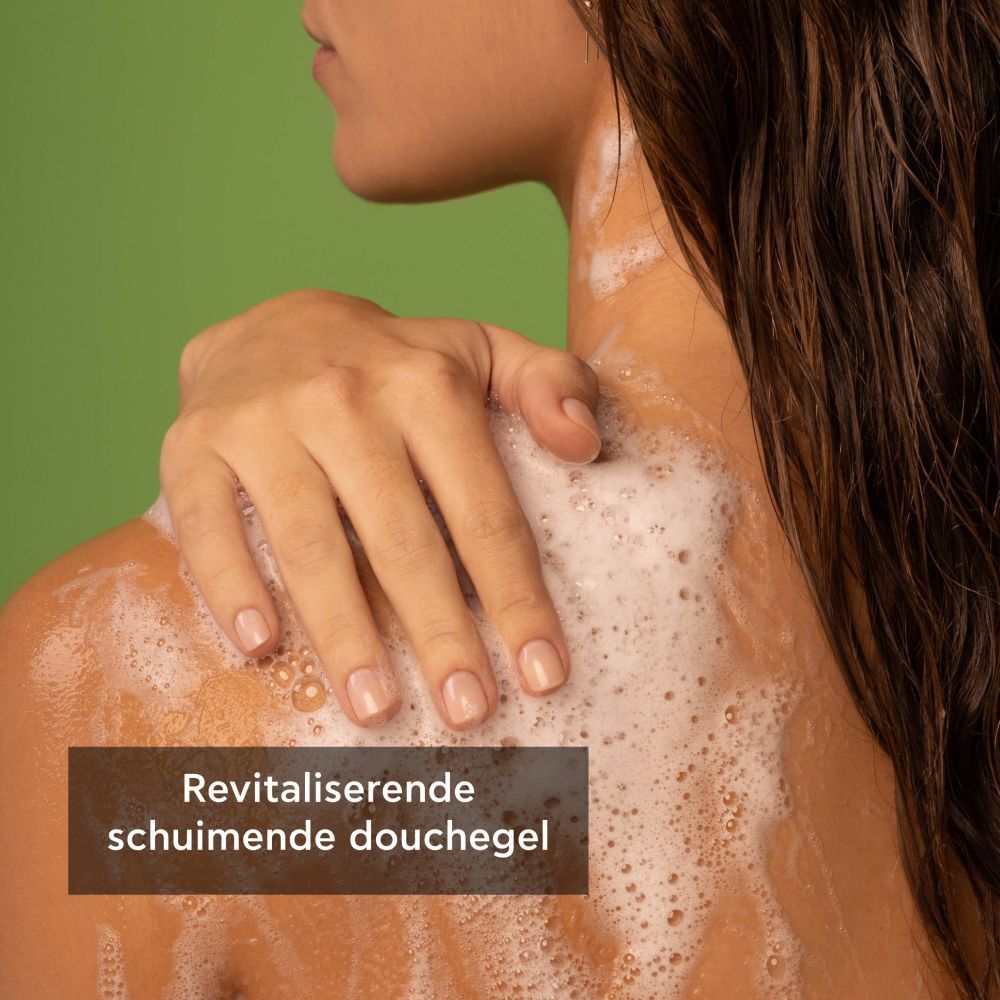 Persoon wast zich. Tekst: Revitaliserende schuimende douchegel. Schuim. Groene achtergrond.