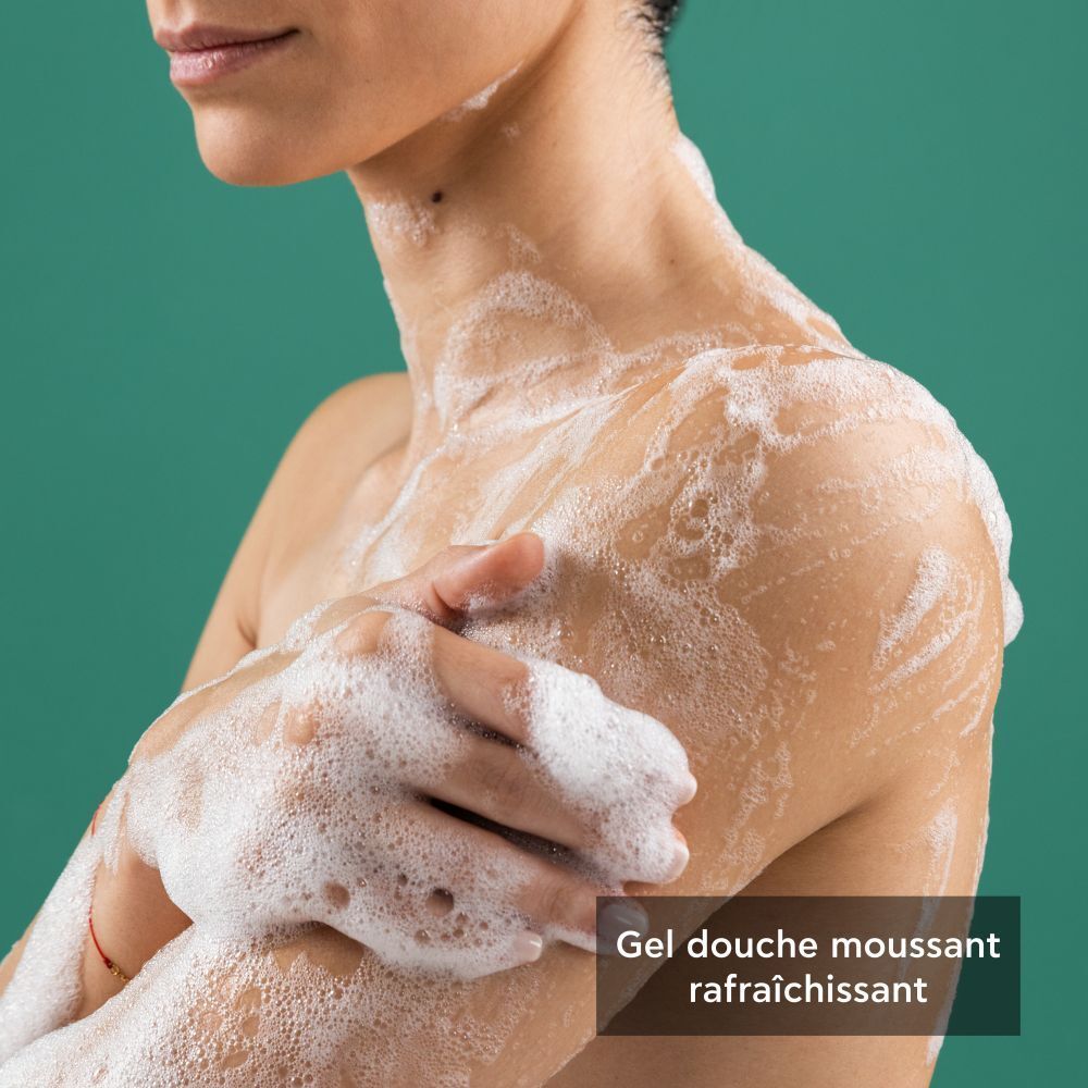 Personne avec de la mousse sur la peau. Texte: Gel douche moussant rafraîchissant.