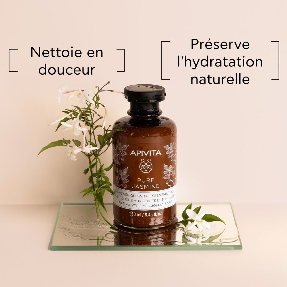 Flacon avec fleurs de jasmin sur une plaque de verre. Texte: Nettoie en douceur, Préserve l'hydratation naturelle.