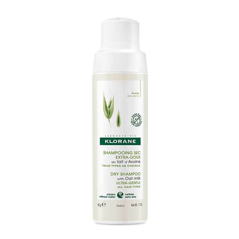 Klorane Trockenshampoo-Flasche. Weißes Behältnis mit grünem Etikett. Enthält Hafermilch. Text: Shampooing Sec Extra-Doux.