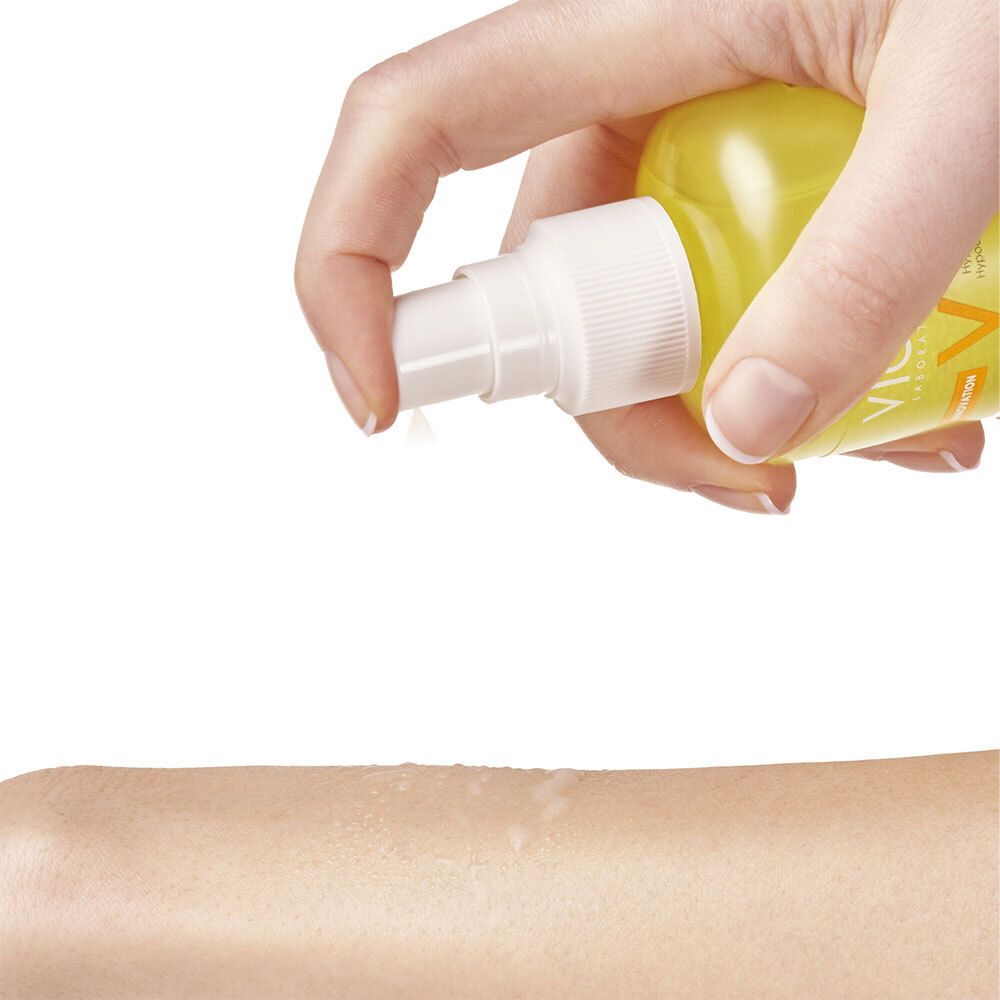 Hand spuit vloeistof op arm. Gele vloeistof, verstuiver.