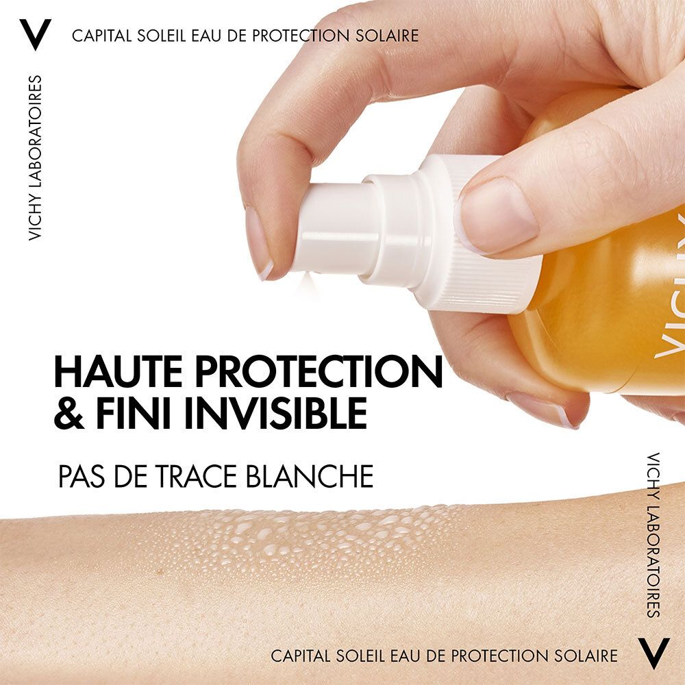 Main vaporisant Vichy Capital Soleil Eau de protection solaire SPF50 sur la peau. Texte: Haute protection & fini invisible.