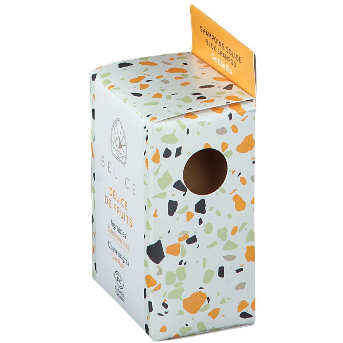 Verpakking voor vaste shampoo. Wit met gekleurde vlekken. Zichtbaar gat. Tekst: BÉLICE DÉLICE DE FRUITS, Agrumes, Bio-certificering.