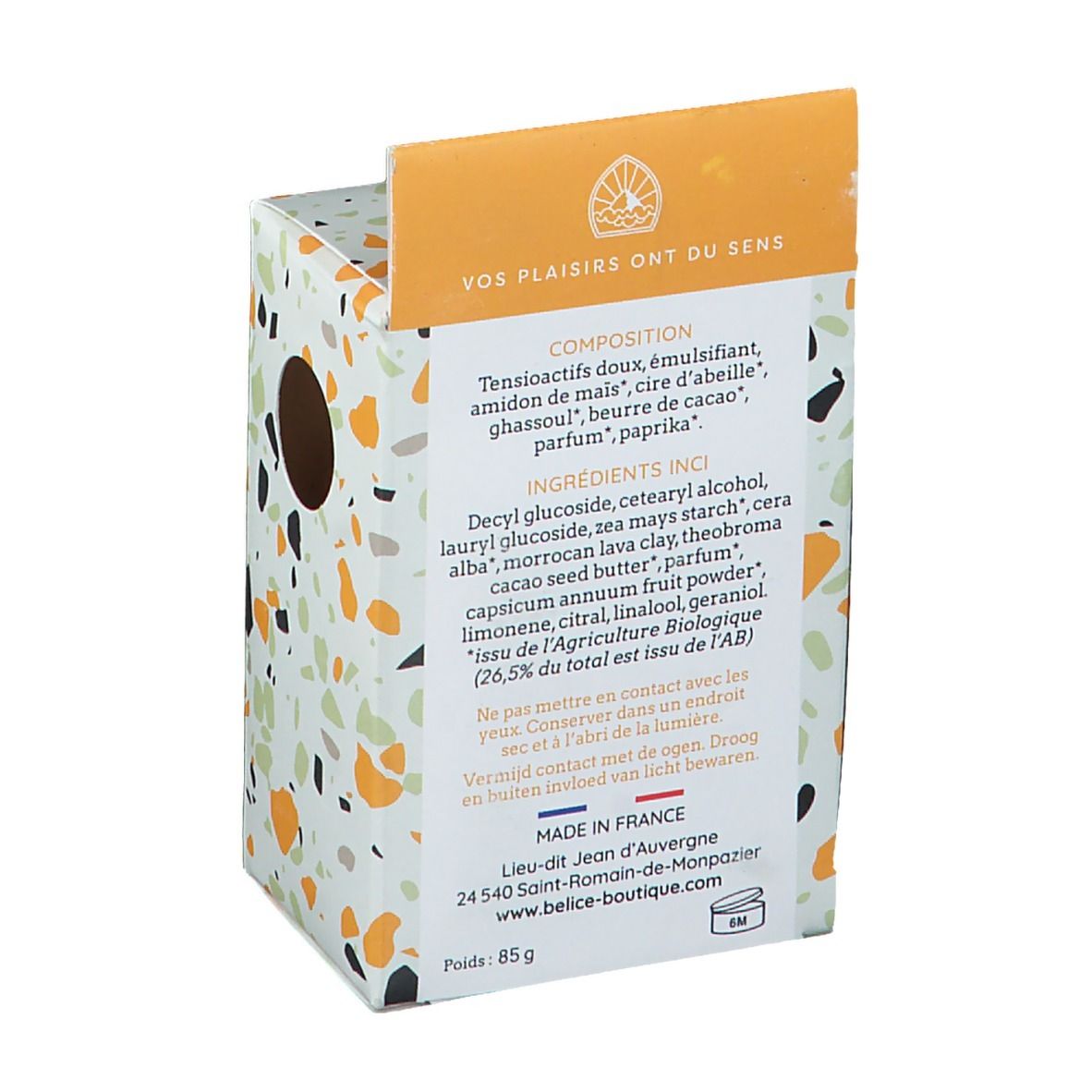 Achterkant van de shampoo verpakking. Tekst: Ingrediënten, Gemaakt in Frankrijk, gewicht 85 g. Gekleurde vlekken op witte achtergrond.