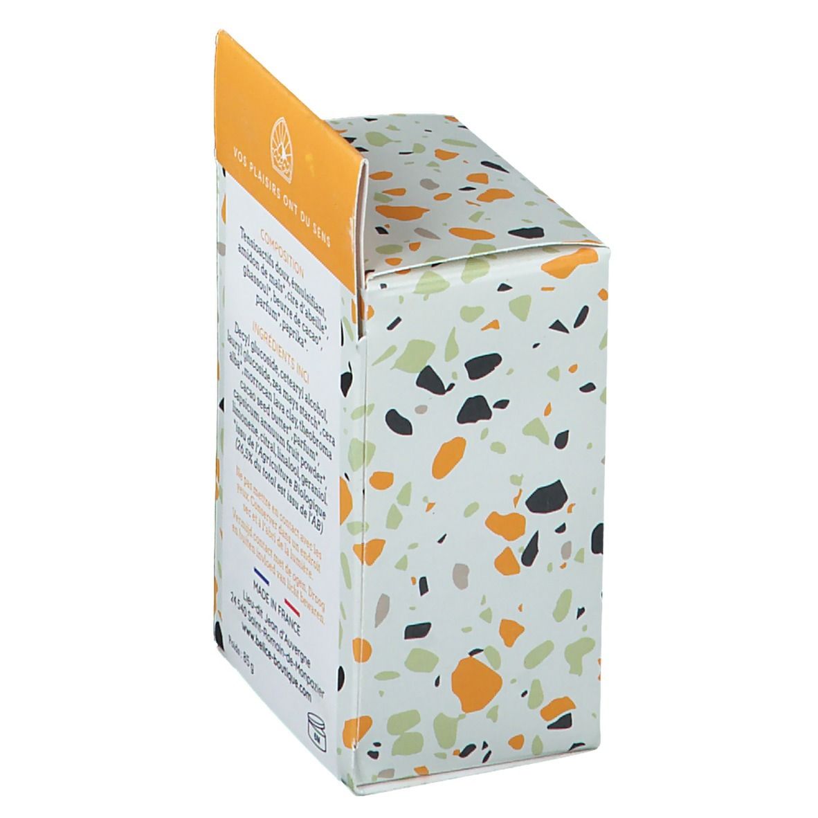 Zijkant van de shampoo verpakking. Tekst: Ingrediënten, Gemaakt in Frankrijk, gewicht 85 g. Gekleurde vlekken op witte achtergrond.