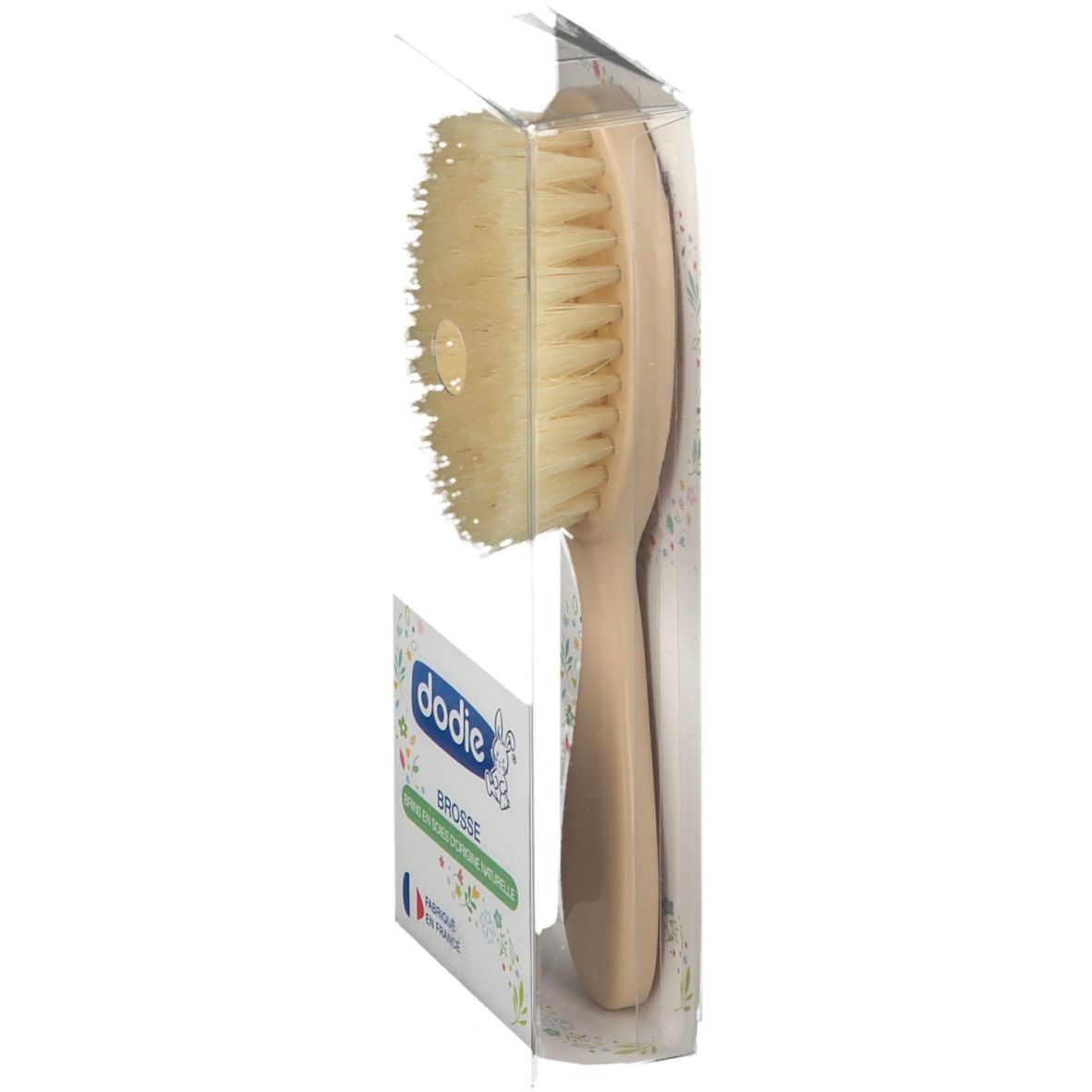 Brosse à cheveux en emballage, vue latérale. Manche clair, poils. Marque Dodie. Fabriqué en France.