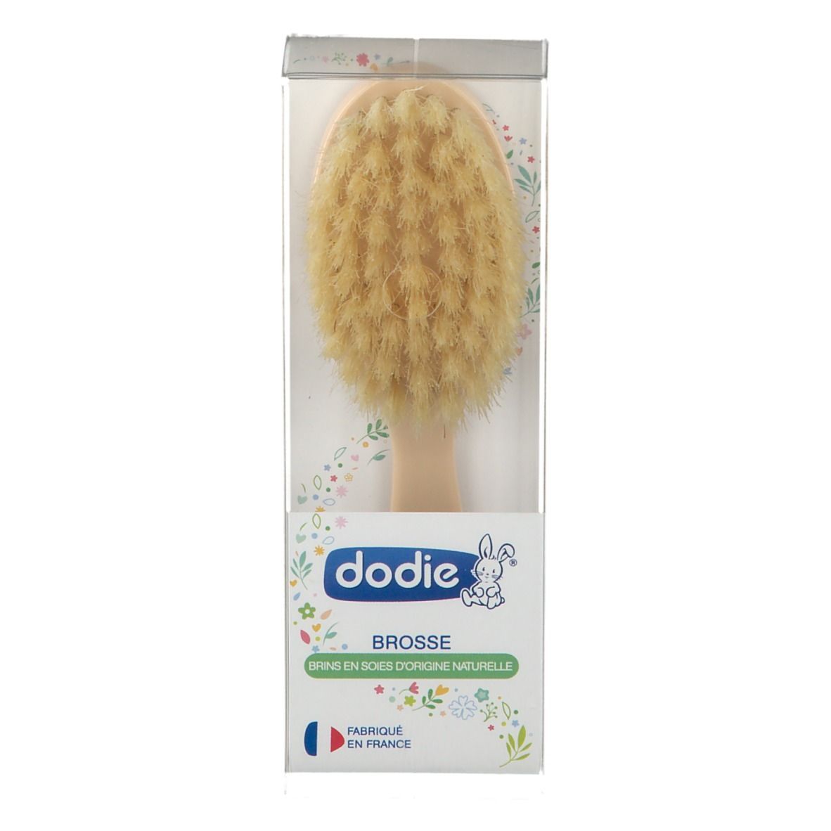 Brosse à cheveux en emballage. Manche clair, poils. Marque Dodie. Texte: Brosse, Fabriqué en France.