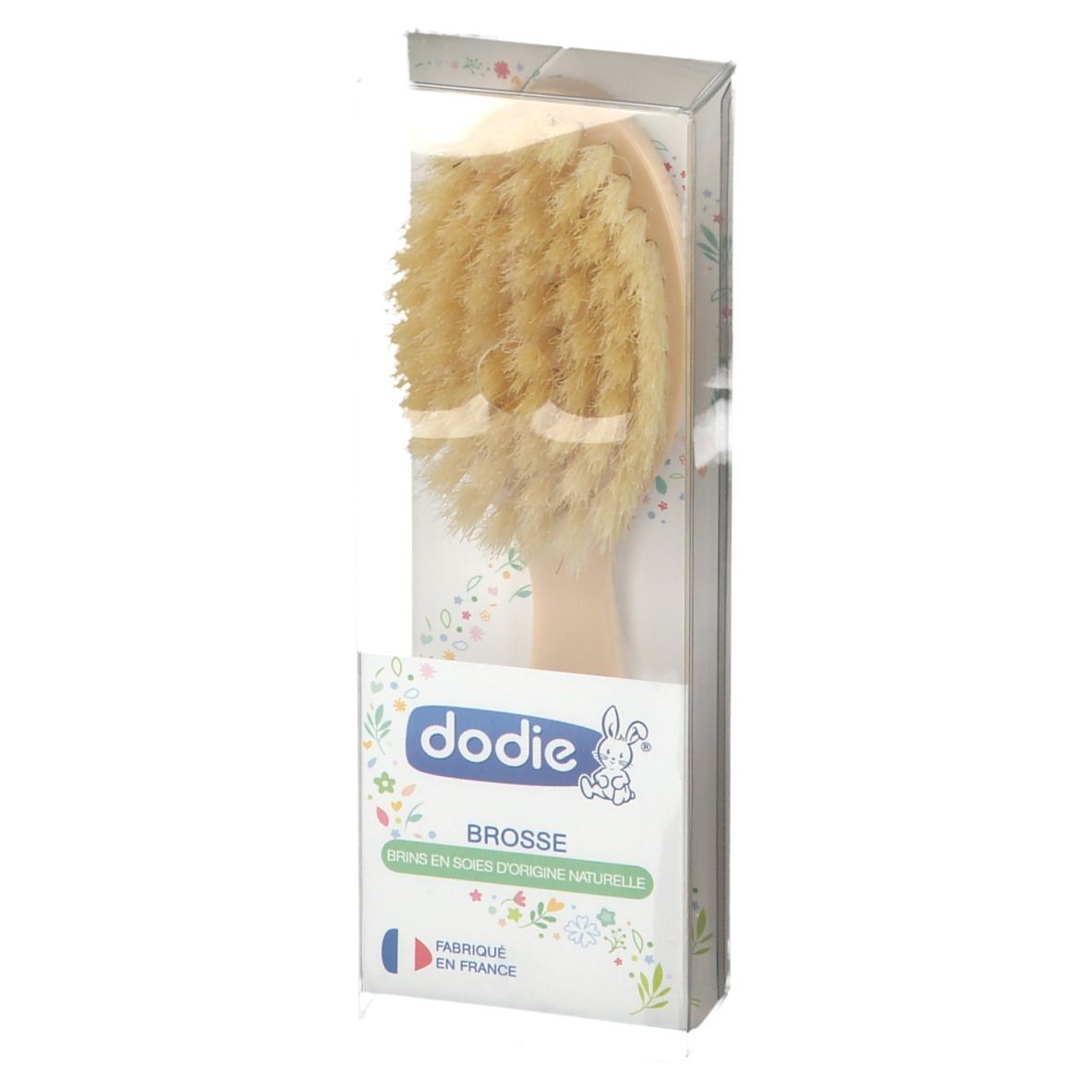 Brosse à cheveux en emballage. Manche clair, poils. Marque Dodie. Texte: Brosse, Fabriqué en France.