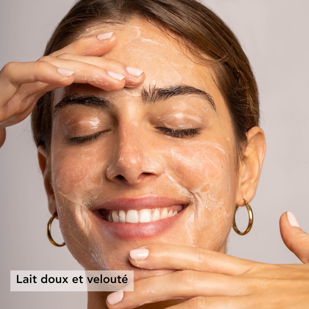 Femme appliquant le produit. Texte: Lait doux et velouté.