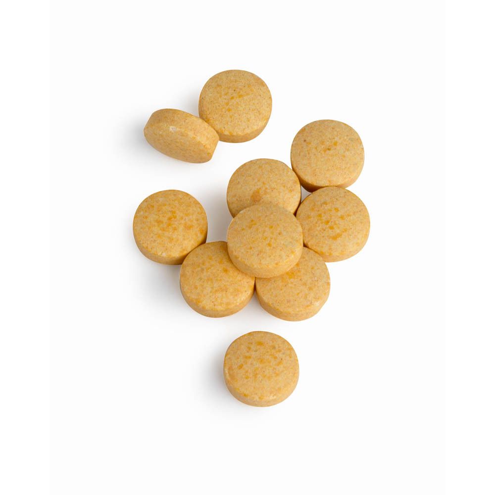 Negen gelige tabletten. Ronde vorm. Op witte achtergrond.