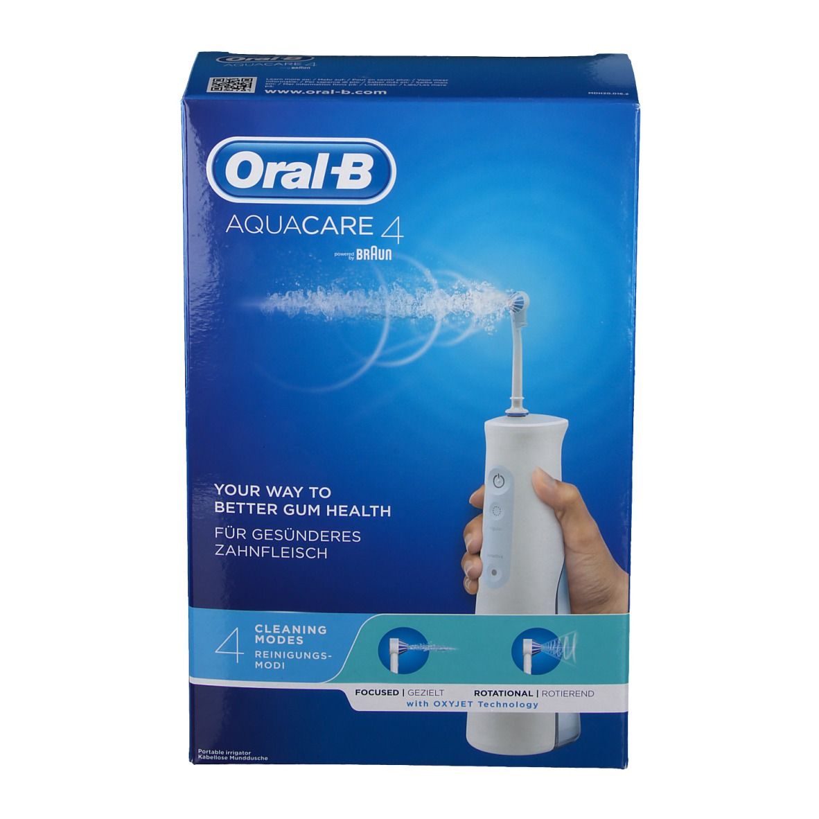 Vue de face de l'emballage Oral-B Aquacare 4. Sur fond bleu, un appareil d'irrigation oral blanc est présenté. Texte : « Your way to better gum health » et « 4 modes de nettoyage ».