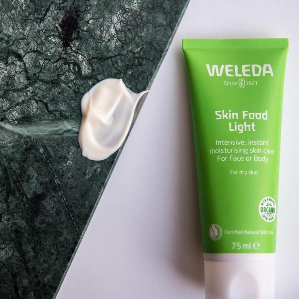 Tube vert Skin Food Light à côté d'une noisette de crème sur fond vert. Avec label bio.