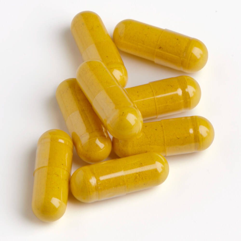 Zeven gele capsules op witte achtergrond. Capsulevorm, glad oppervlak.