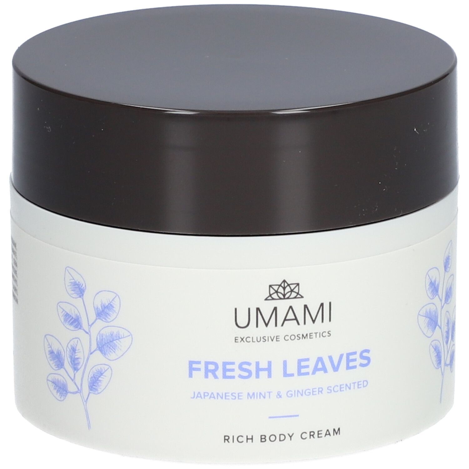 Weißer Tiegel mit braunem Deckel. Aufschrift: UMAMI, FRESH LEAVES, Japanese Mint & Ginger Scented, Rich Body Cream. Blätter-Dekor.