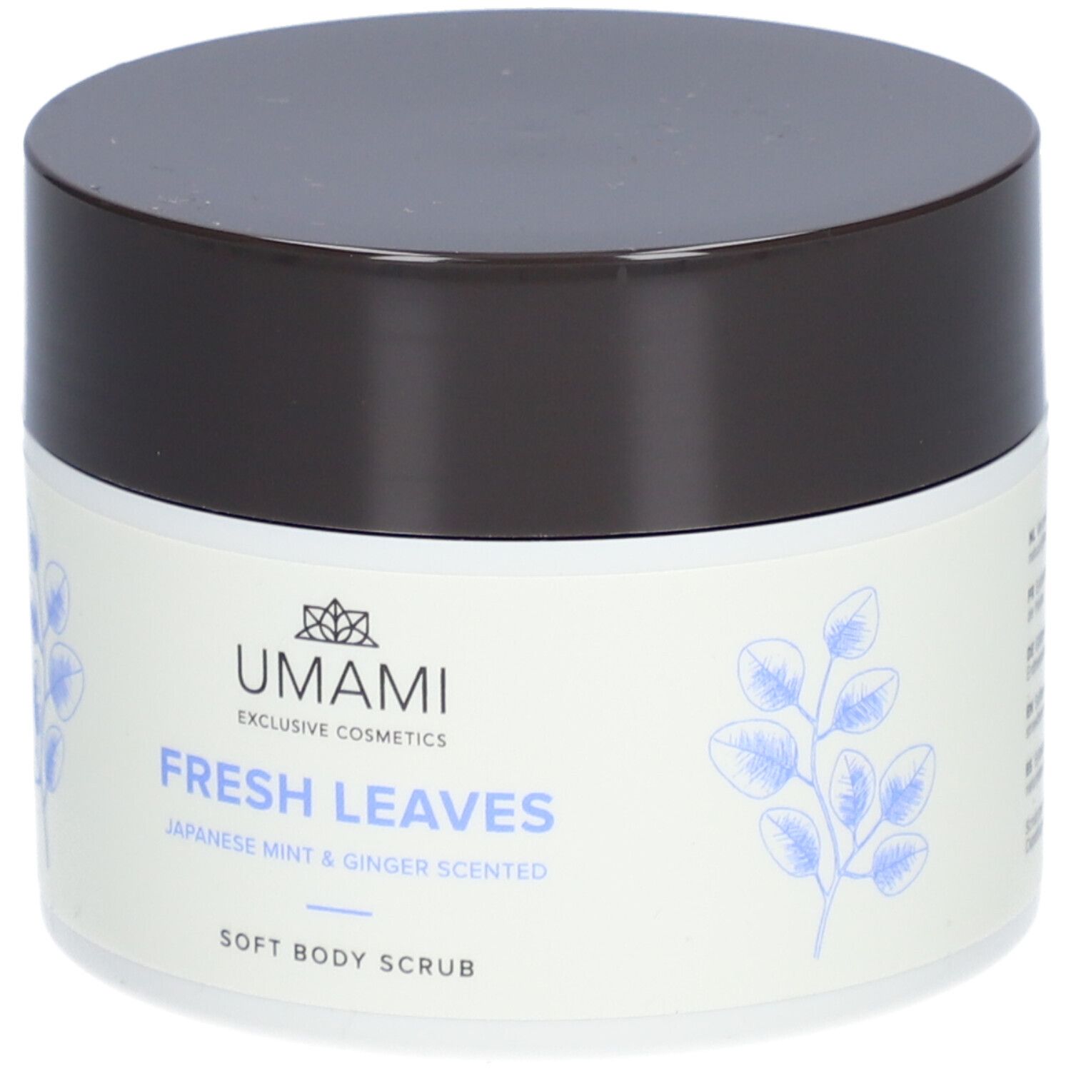 Pot blanc avec couvercle marron. Inscription : UMAMI, FRESH LEAVES, Japanese Mint & Ginger Scented, Soft Body Scrub.